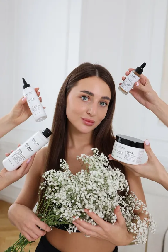 Modelka z produktami RE/GROW i kwiatami